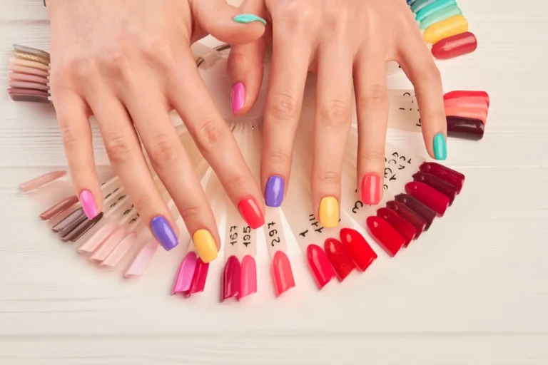 Uñas con esmalte de colores y paleta de muestras en servicio de manicura en Ari Martínez Beauty