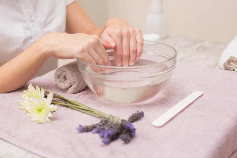 Remojo de manos en agua para preparación de manicura en Ari Martínez Beauty