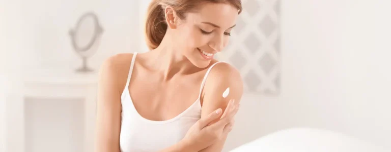 Mujer aplicándose crema hidratante en el brazo en Ari Martínez Beauty